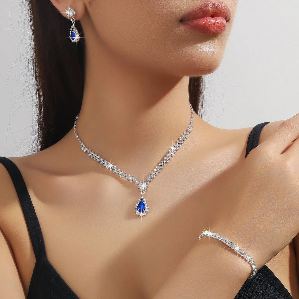 Claw chain necklace and matching drop earrings set with rhinestones in multiple colours.