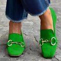 Green flat bottom loafers with a round toe and metal fastener on the front.