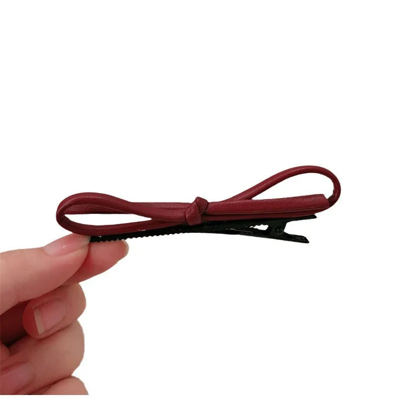 Wine red leather bow hair barrettes showing handcrafted details and bow design