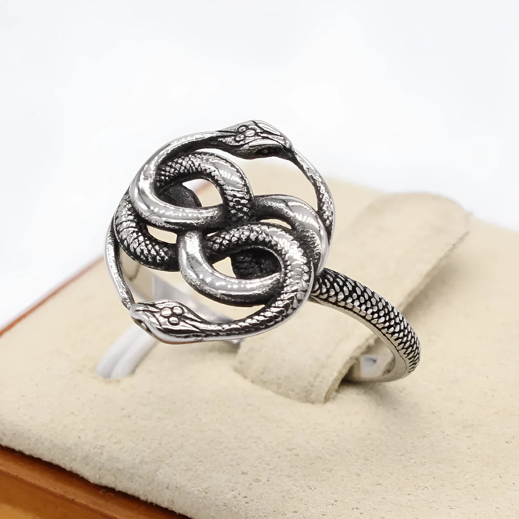 Close-up of a titanium steel double snake ring in a retro style on a grey background.