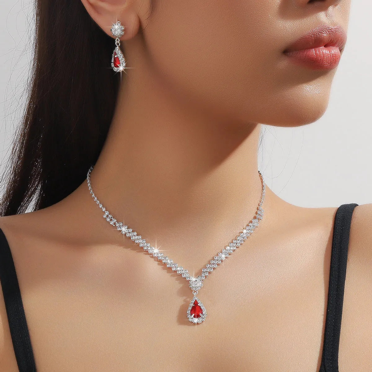 Claw chain necklace and matching drop earrings set with rhinestones in multiple colours.