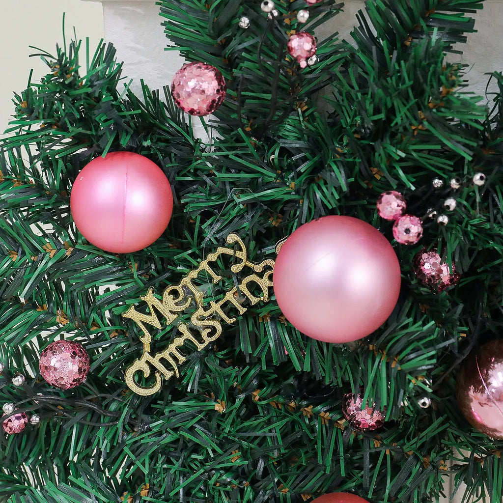 2.7 metre long pink artificial Christmas rattan vine decoration with small berries and leaves against a wall.