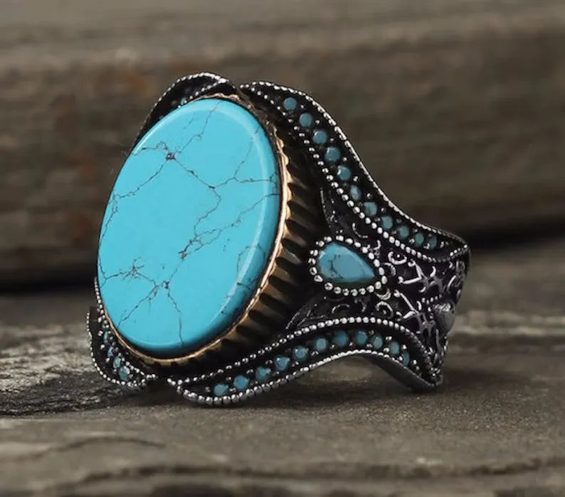Round turquoise men's ring with antique silver alloy band showing stone detail and metallic finish