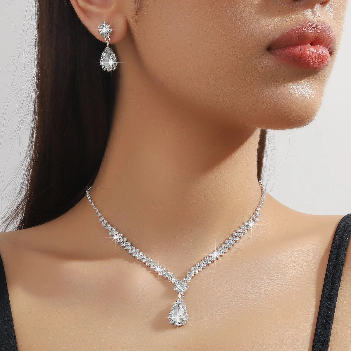 Claw chain necklace and matching drop earrings set with rhinestones in multiple colours.
