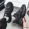 Men's beige and black low-top lace-up sneakers with mesh upper and rubber platform sole.