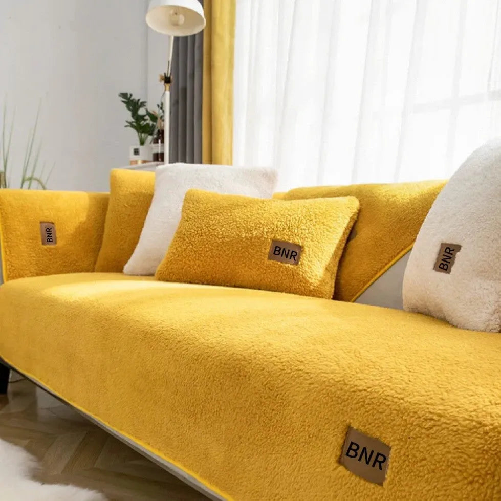 Lambswool-style solid colour sofa cover and pillow on a grey sofa.