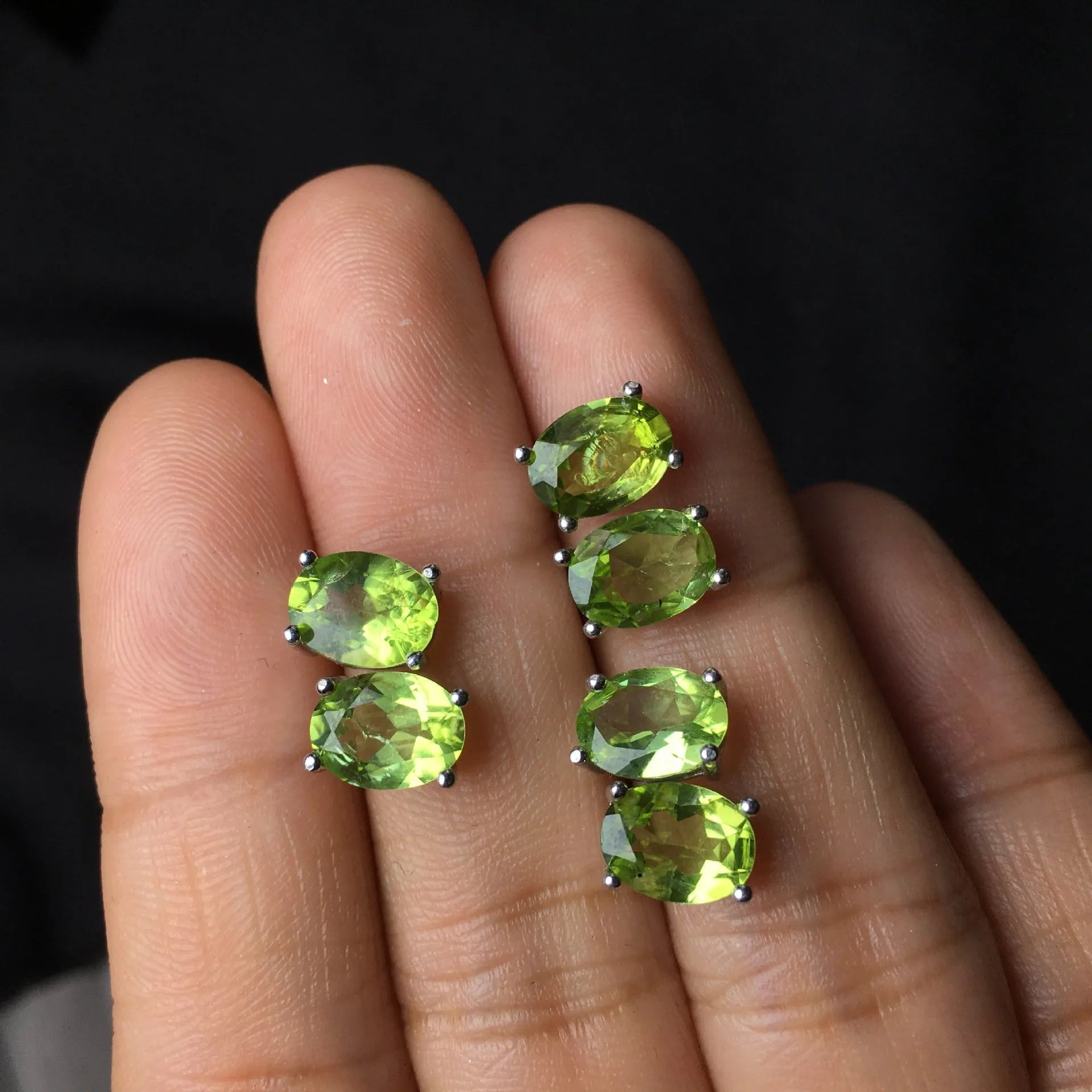 Natural grass green olivine faceted stud earrings in S925 sterling silver on a white background.