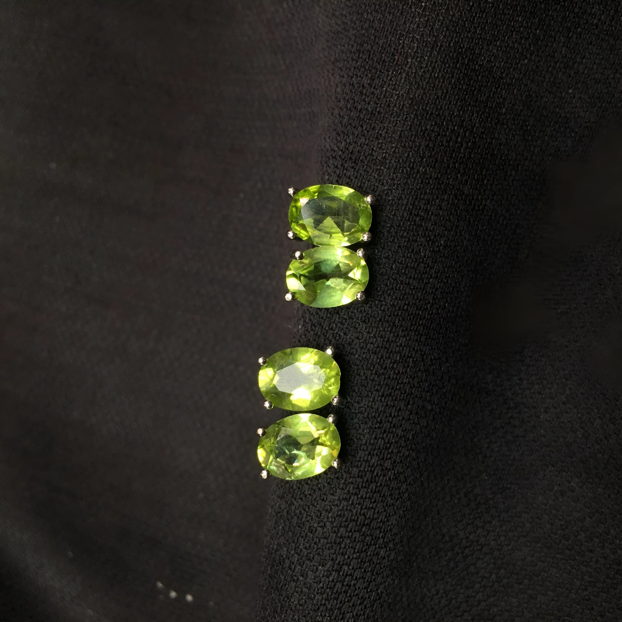 Natural grass green olivine faceted stud earrings in S925 sterling silver on a white background.