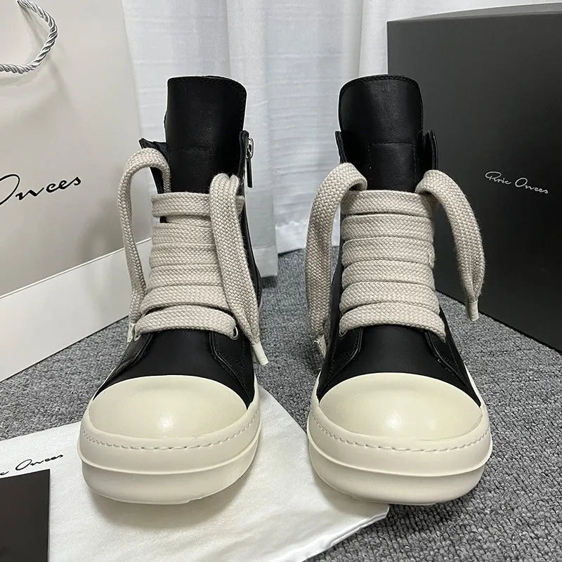 Black high-top leather unisex sneakers with a side zipper on a white background.
