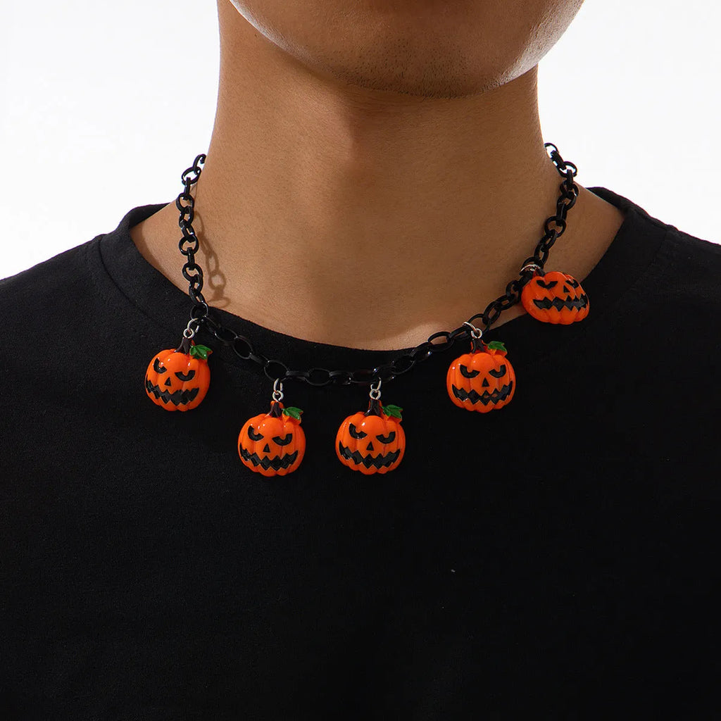 Halloween necklace showing a cartoon ghost and pumpkin acrylic pendant on a metal chain, in mixed colours.