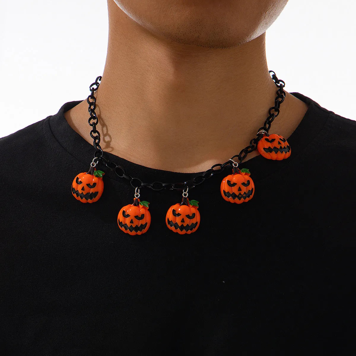 Halloween necklace showing a cartoon ghost and pumpkin acrylic pendant on a metal chain, in mixed colours.