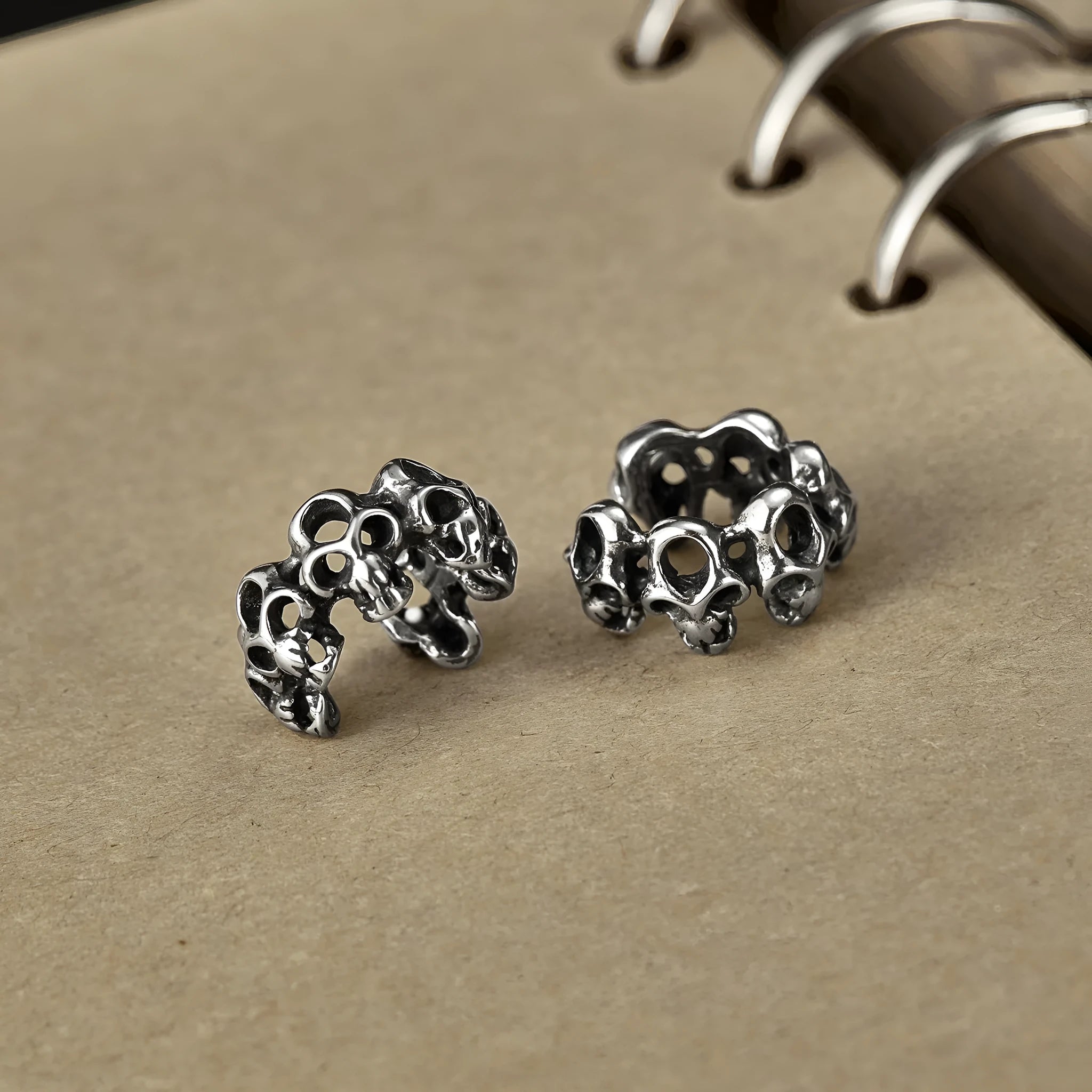 Stainless steel clip-on earrings with a hollow geometric skull design.