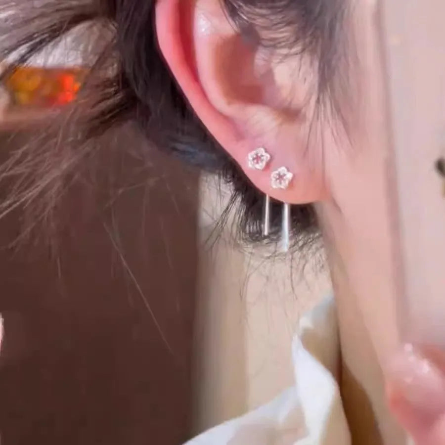 Silver flower stud earrings with hollow petal designs on alloy posts for women