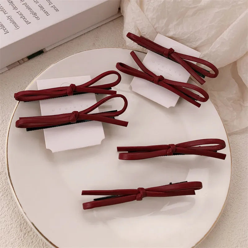 Wine red leather bow hair barrettes showing handcrafted details and bow design