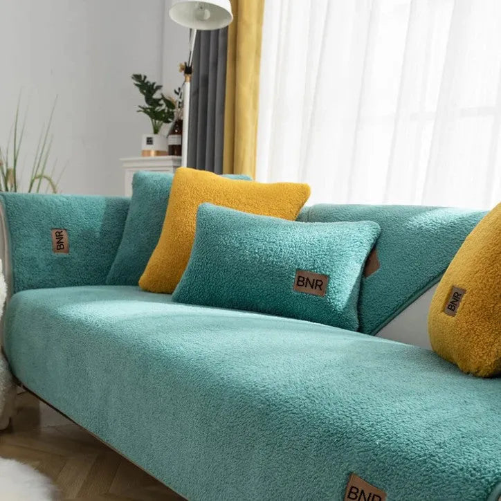 Lambswool-style solid colour sofa cover and pillow on a grey sofa.