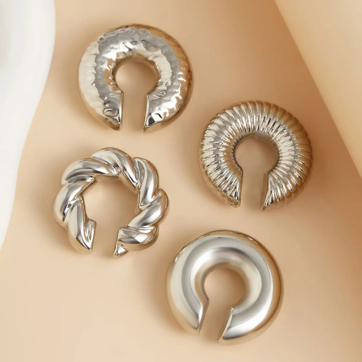 Geometric gold and silver ear clips for women without pierced ears showing exaggerated shape design