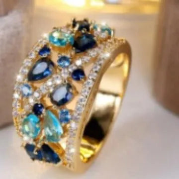Women's round hollow copper ring with gemstone accents in gold or platinum plating with white or blue stones