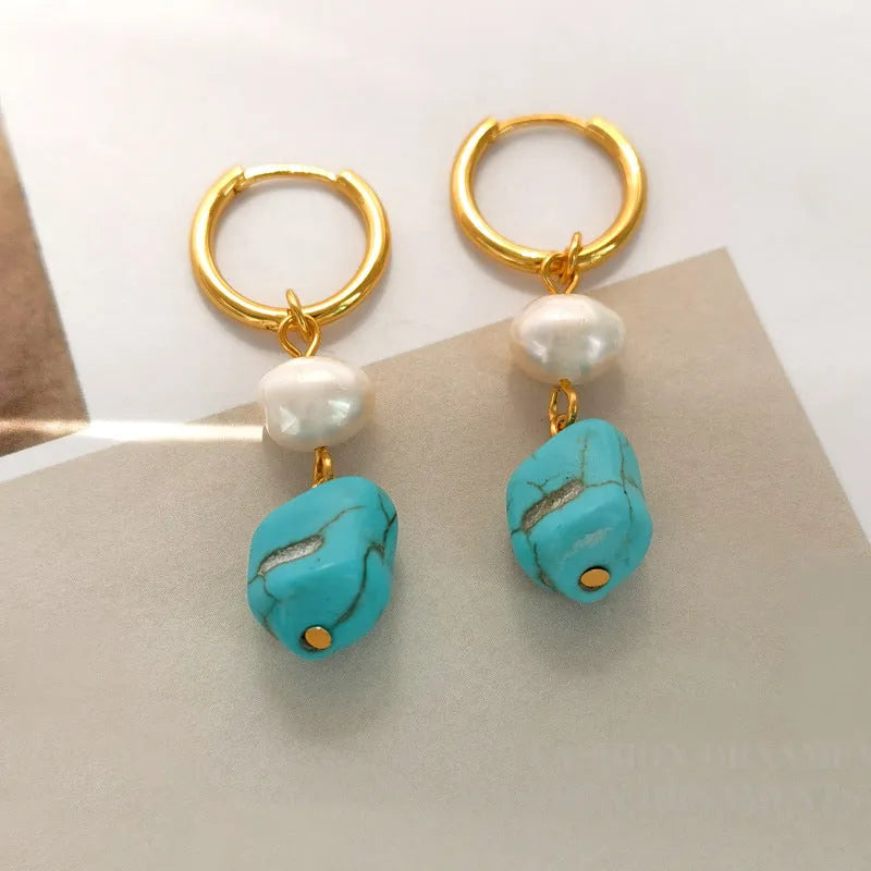 A pair of geometric turquoise and cultured pearl clip-on earrings on a copper setting.