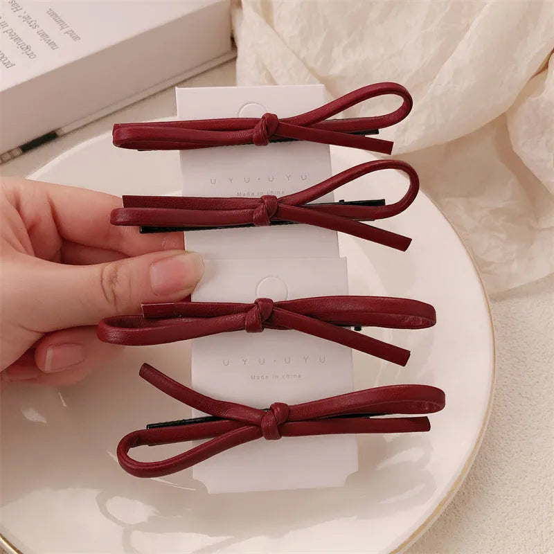 Wine red leather bow hair barrettes showing handcrafted details and bow design