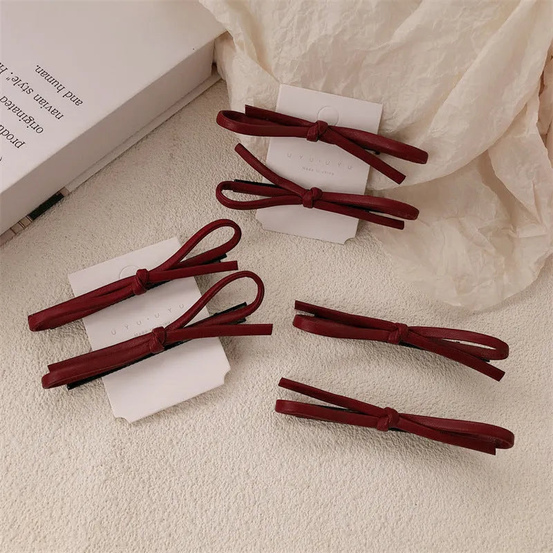 Wine red leather bow hair barrettes showing handcrafted details and bow design