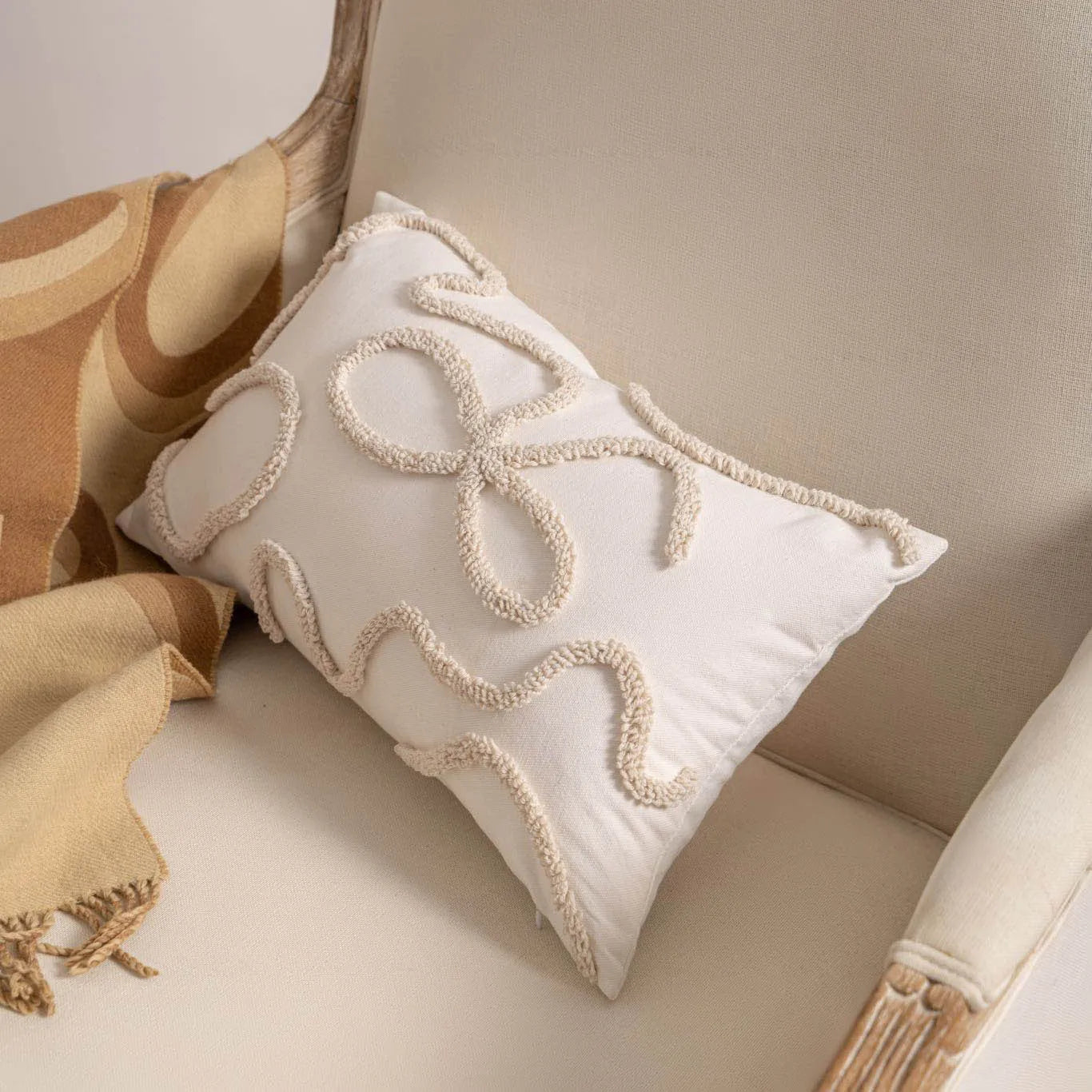 Knitted cushion cover with tassel trim in a printed spiral dots pattern, shown in 45x45cm size.
