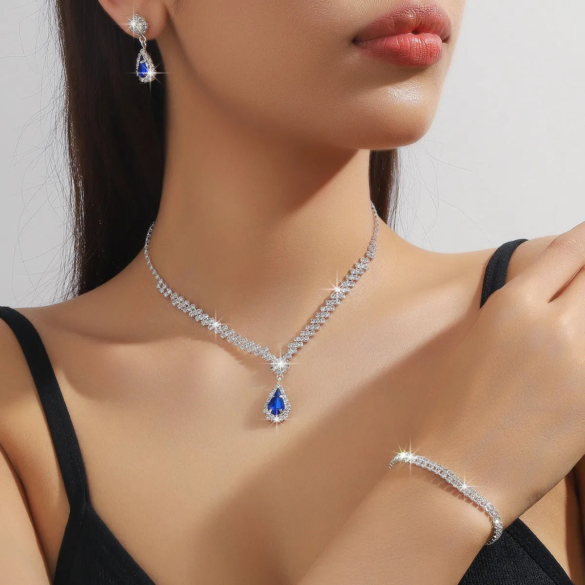 Claw chain necklace and matching drop earrings set with rhinestones in multiple colours.