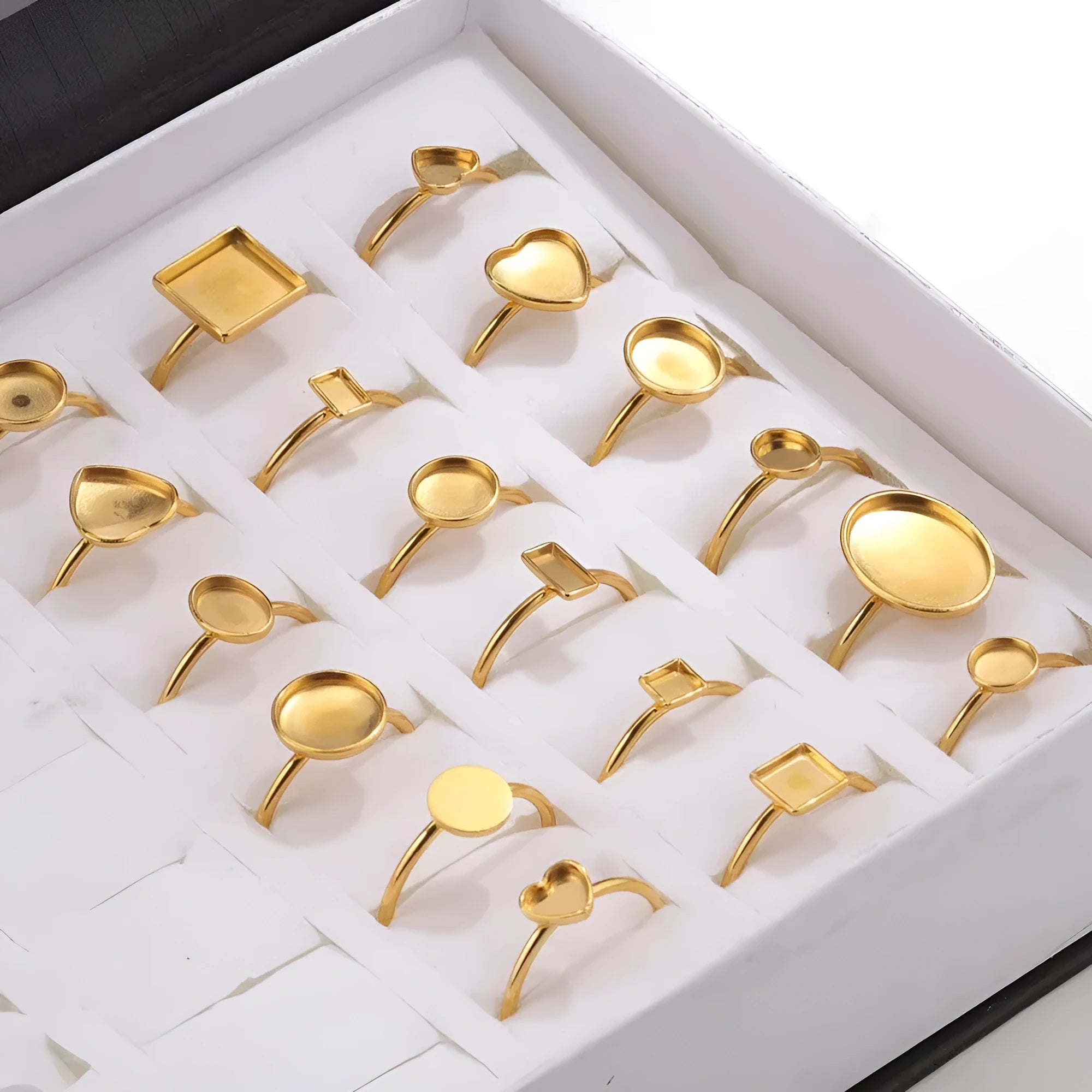 Golden stainless steel ring settings in various shapes including oval, round, square, rectangle, and heart designs