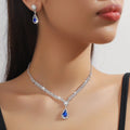 Claw chain necklace and matching drop earrings set with rhinestones in multiple colours.
