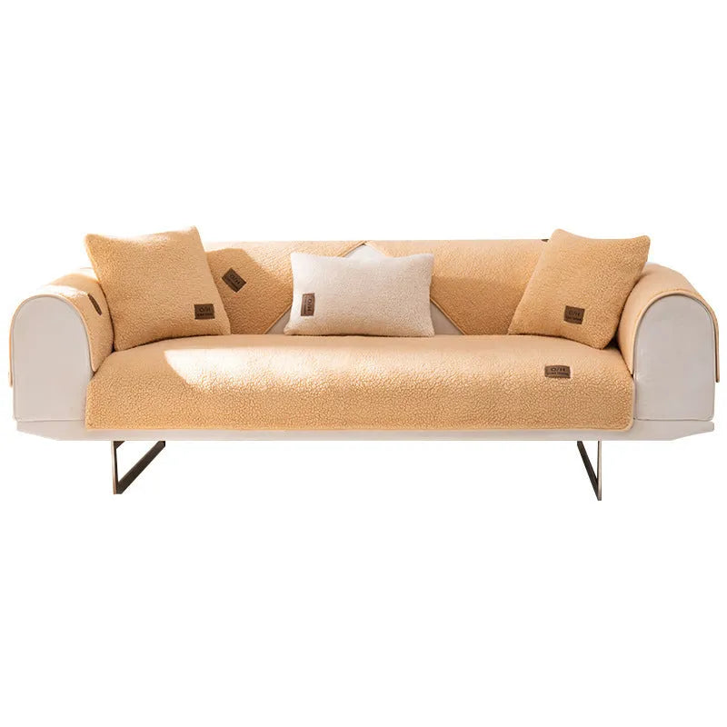 Lambswool-style solid colour sofa cover and pillow on a grey sofa.