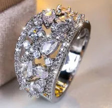 Women's round hollow copper ring with gemstone accents in gold or platinum plating with white or blue stones