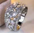 Women's round hollow copper ring with gemstone accents in gold or platinum plating with white or blue stones
