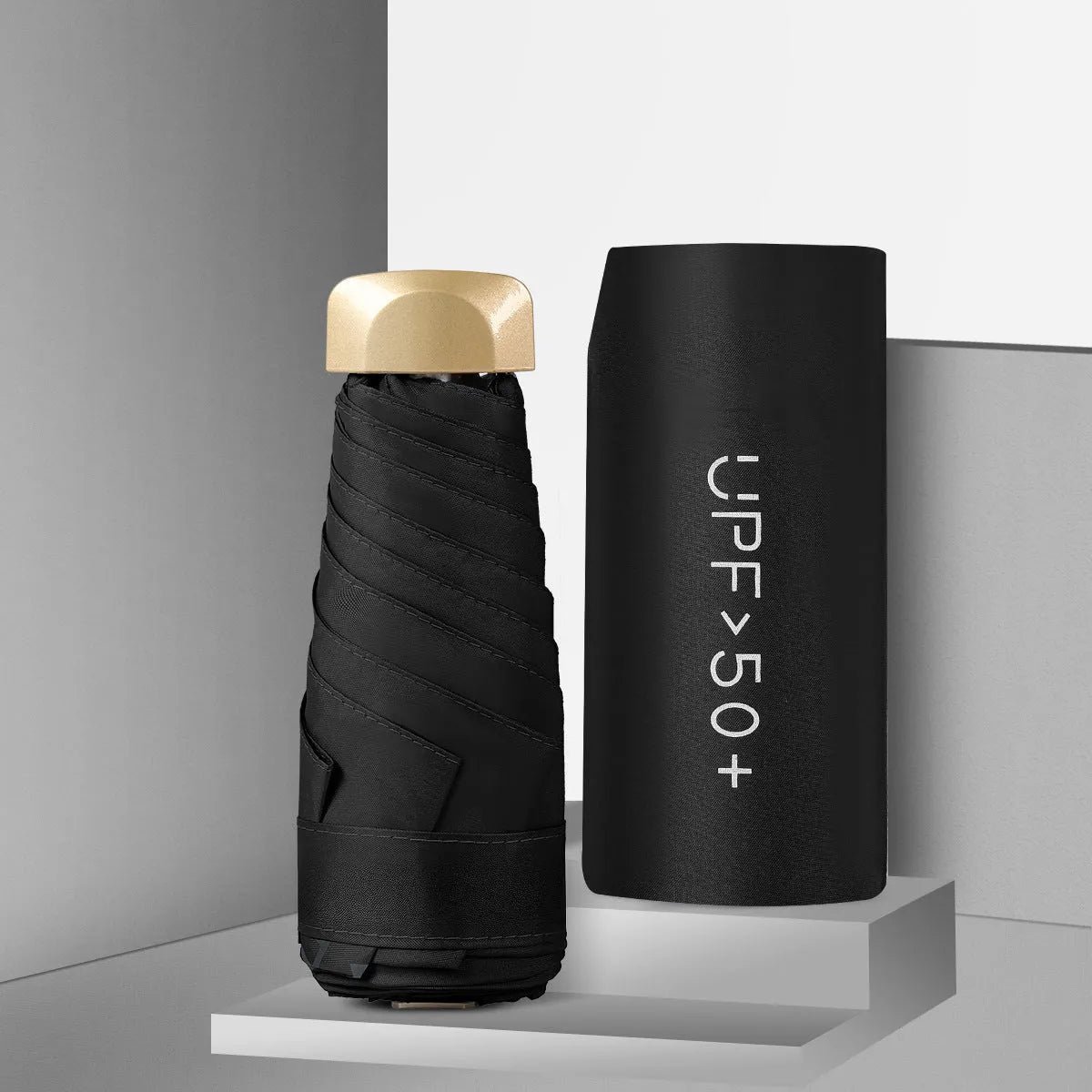 Closed black five-fold mini pocket sun umbrella with rubber handle showing compact size.