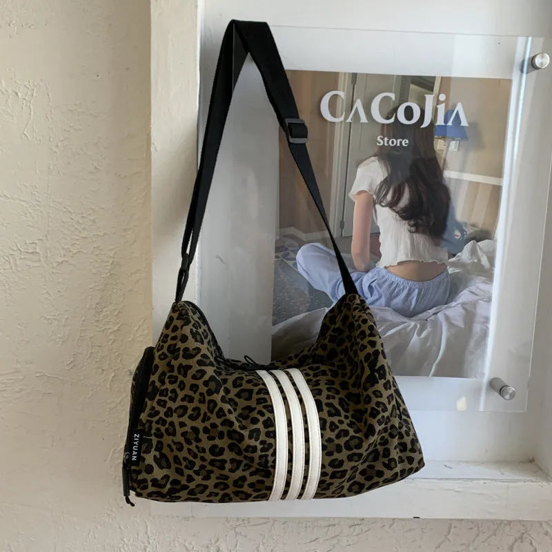 Sports style messenger bag in leopard print pattern with visible stitching and cross-body strap