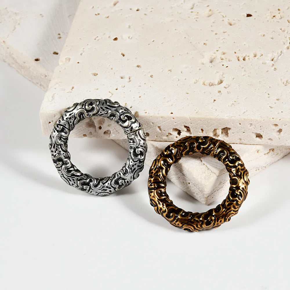 A pair of stainless steel fashion earrings featuring a geometric totem pattern with an electroplated coloured finish.