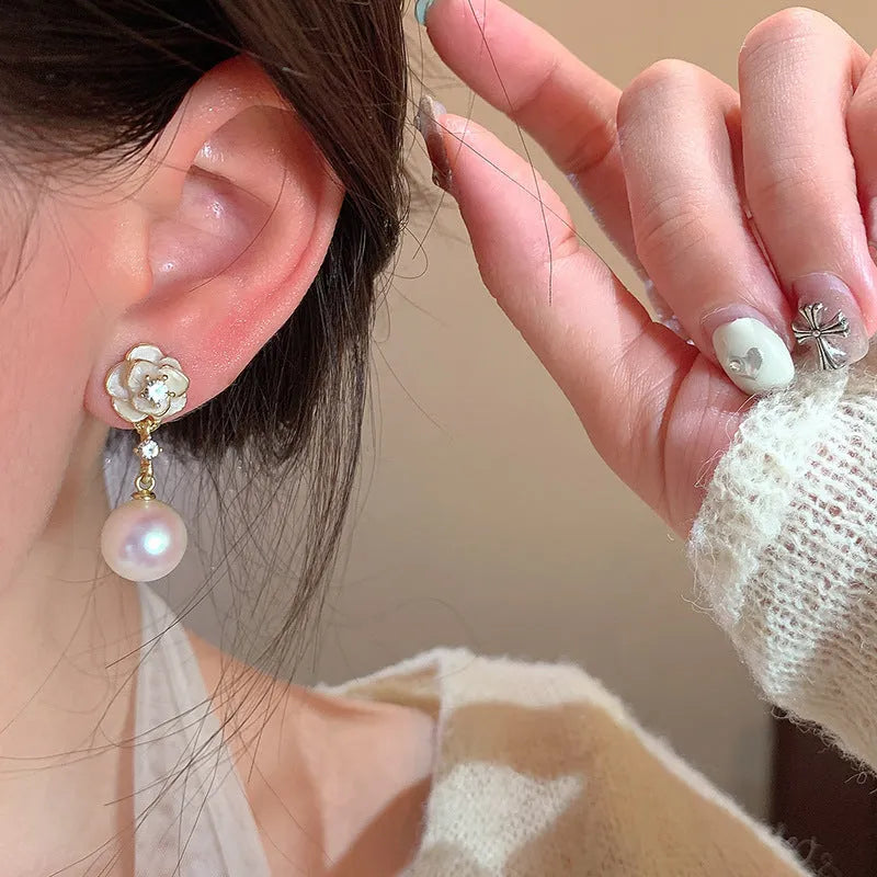 A pair of camellia flower design stud earrings for women in a pearl-white alloy.