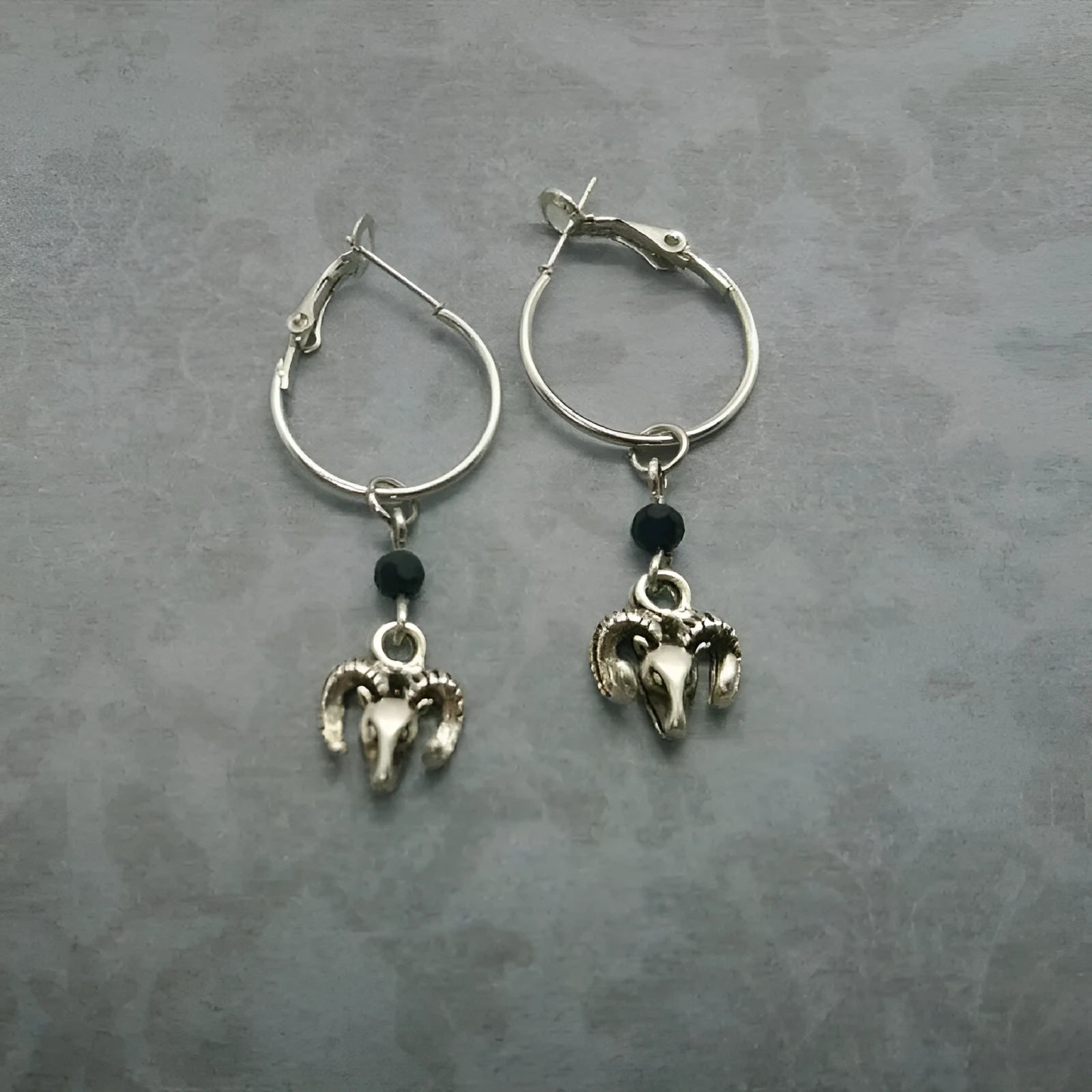 Silver coloured round ring earrings with Tibetan antelope design inspiration