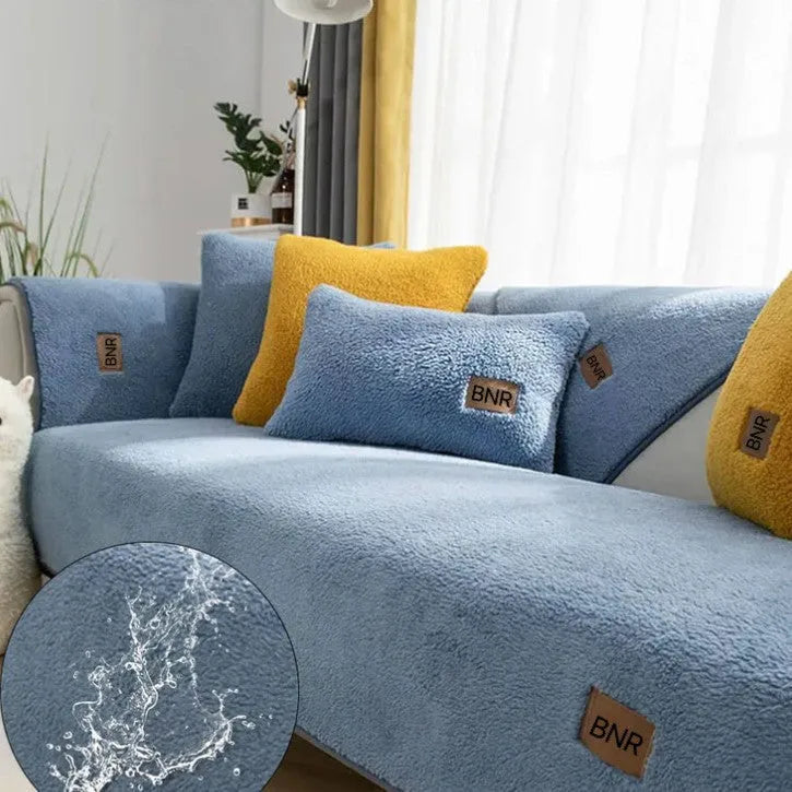 Lambswool-style solid colour sofa cover and pillow on a grey sofa.