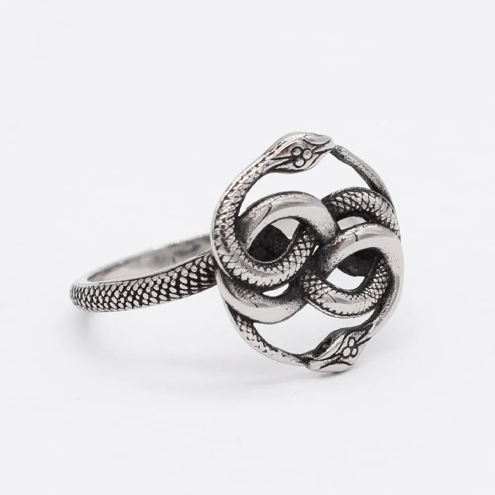 Close-up of a titanium steel double snake ring in a retro style on a grey background.
