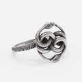Close-up of a titanium steel double snake ring in a retro style on a grey background.