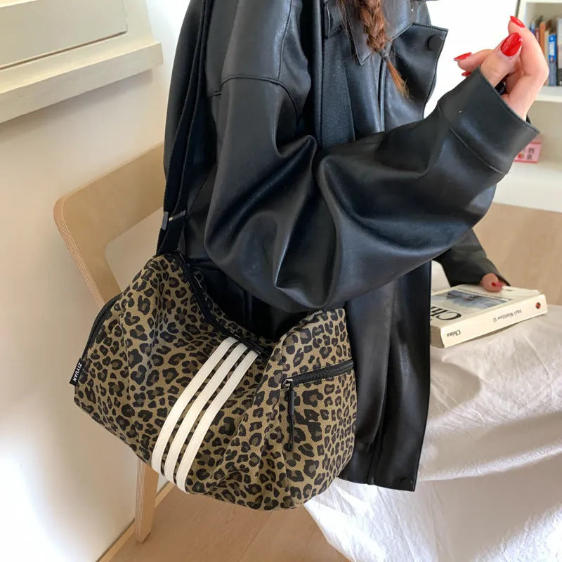 Sports style messenger bag in leopard print pattern with visible stitching and cross-body strap