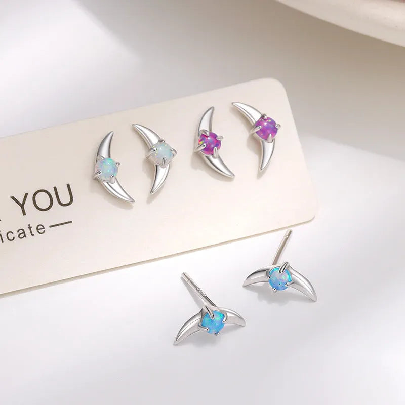 Women's geometric 925 silver earrings with blue stone in gold setting.