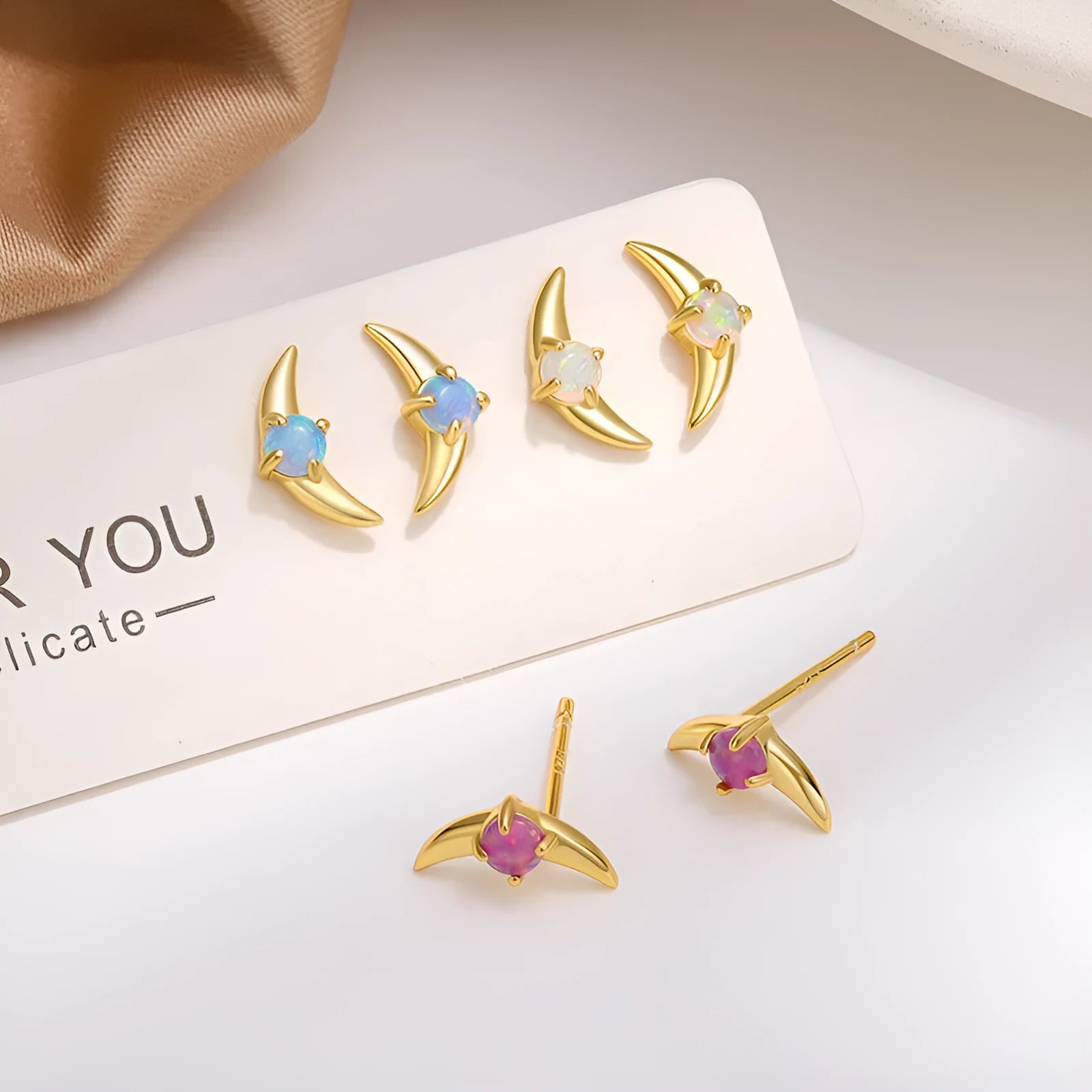 Women's geometric 925 silver earrings with blue stone in gold setting.