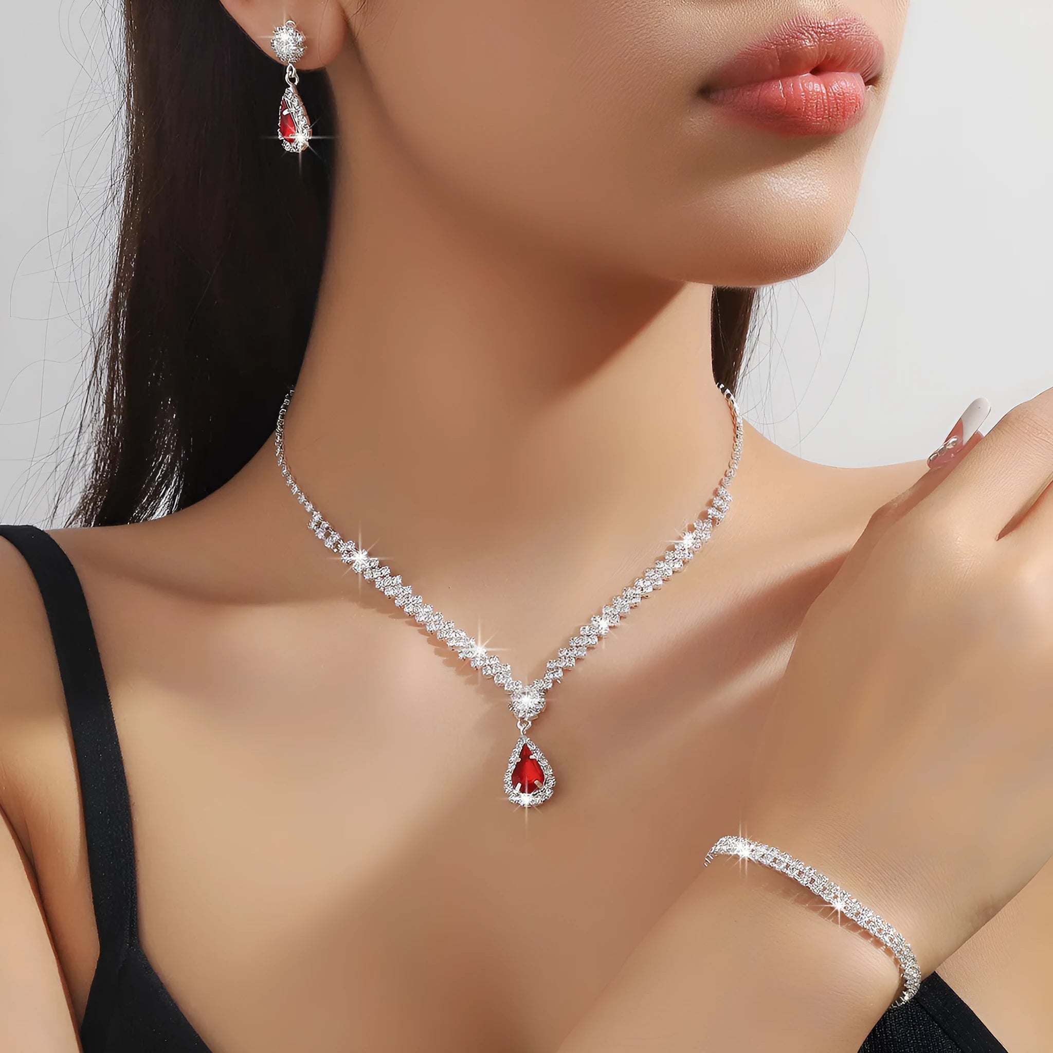 Claw chain necklace and matching drop earrings set with rhinestones in multiple colours.