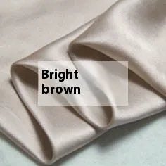 Double-sided silk duvet cover in a solid colour, shown in bright brown on a bed.