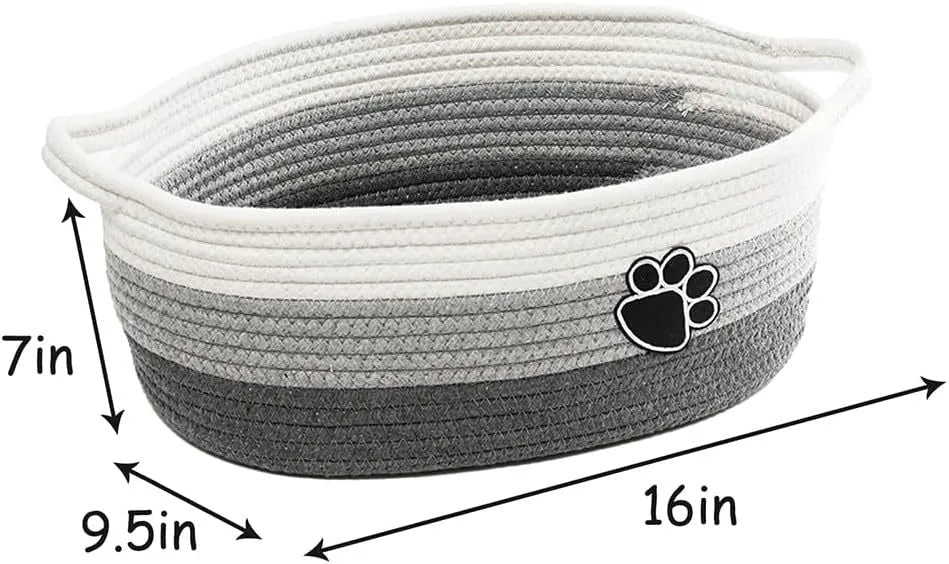 Light beige handmade woven cotton rope storage basket with handle on a wooden floor.