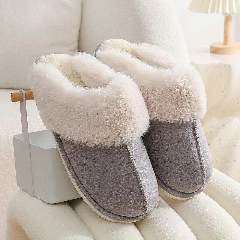 Brown plush indoor slippers with round toe, decorative stitching, and a light-coloured anti-slip sole.