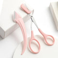 White and pink curved moon-shaped eyebrow trimming knife with a comb on a white background.