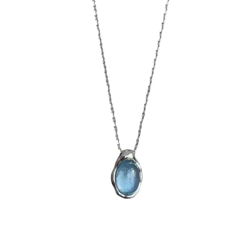Geometric navy blue and platinum colour water drop pendant necklace on a cross chain.