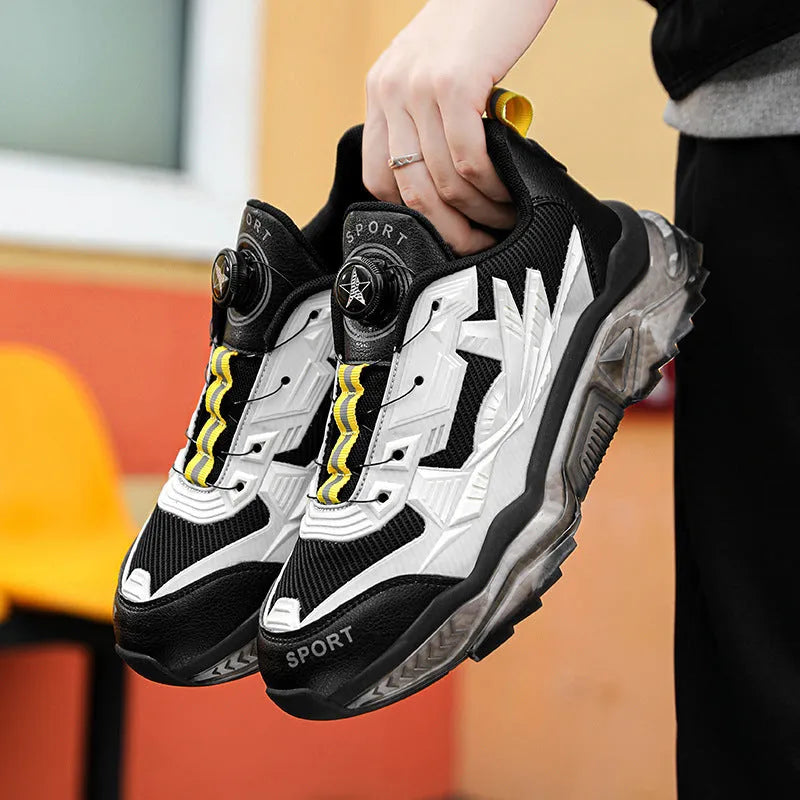 Men's black casual shoes with rotating button fastener and mesh upper on a rubber platform sole.