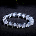 Women's white crystal pyramid bead bracelet with a silver ruyi charm on a white background.